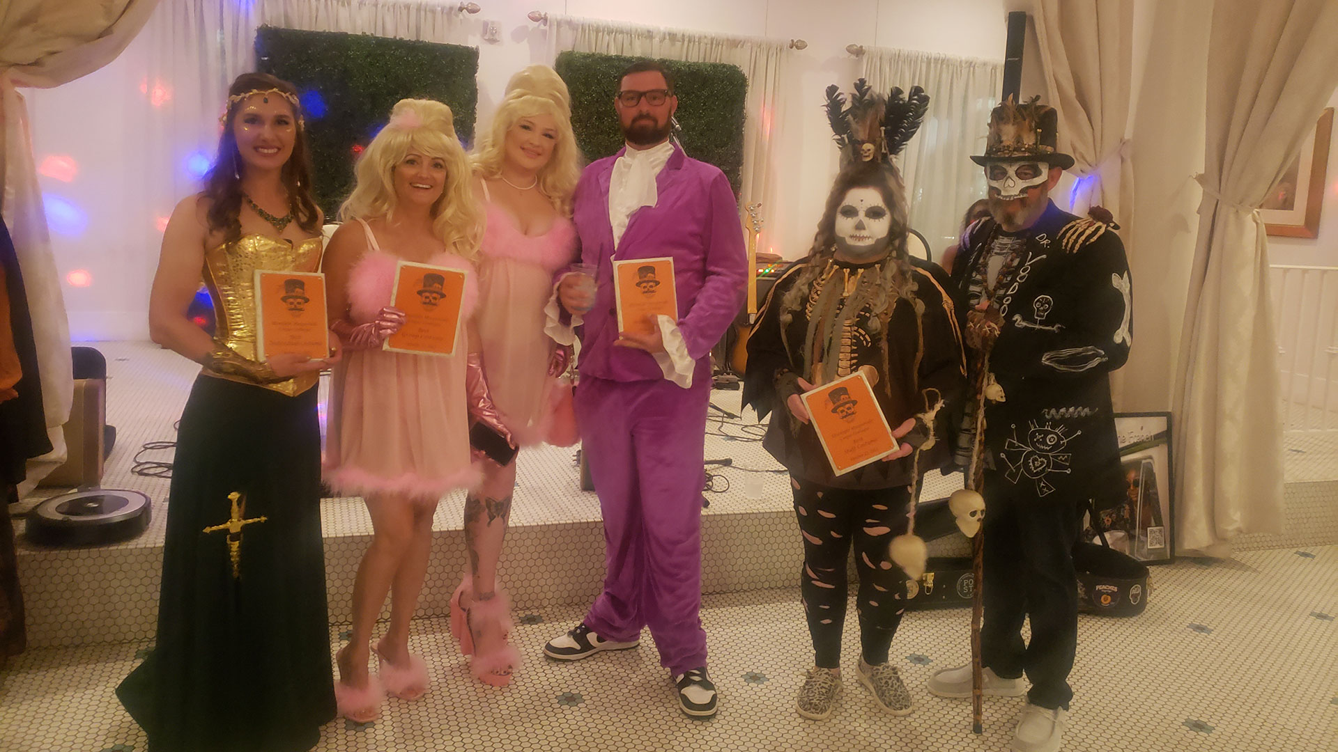 men and women in various costumes holding their winning plaques