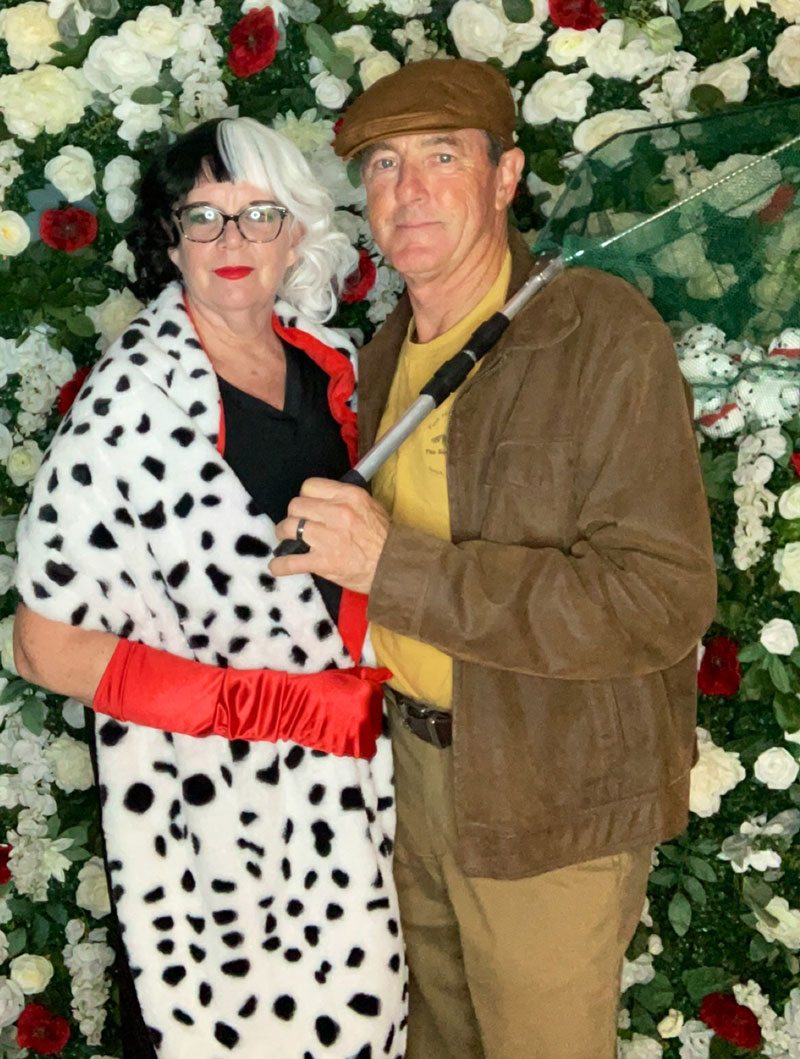 a man and woman dressed in costume as Cruella deVille and a dogcatcher