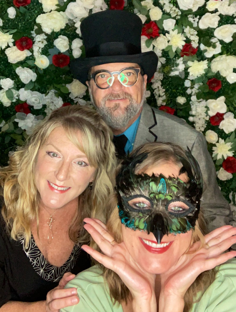 a man and two women dressed in costumes with masks